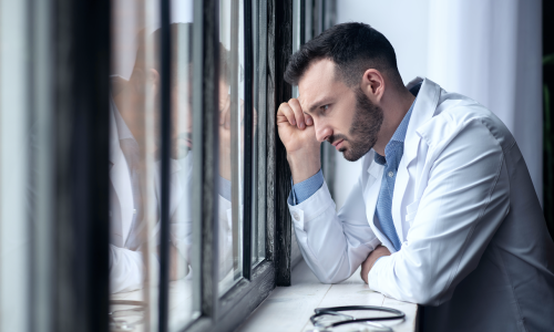 bearded-male-doctor-in-white-robe-looking-sad-2024-10-16-23-30-49-utc 1